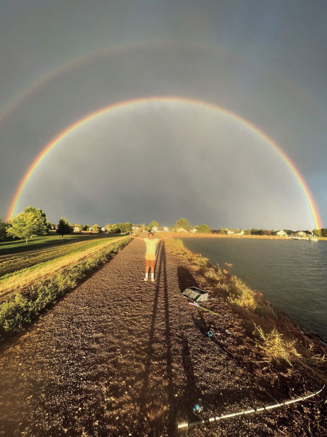 Riane Coleman poses beneath a beautiful double rainbow